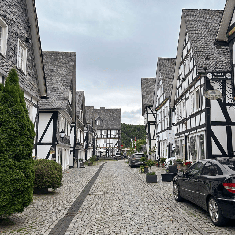 A view of a cobblestone street with white half-timbered buildings