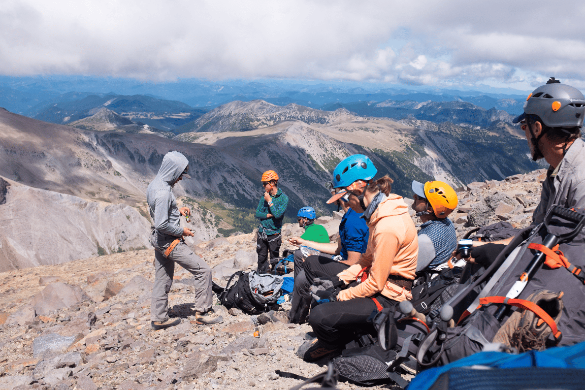 Guide looking off at a distant route while team relaxes