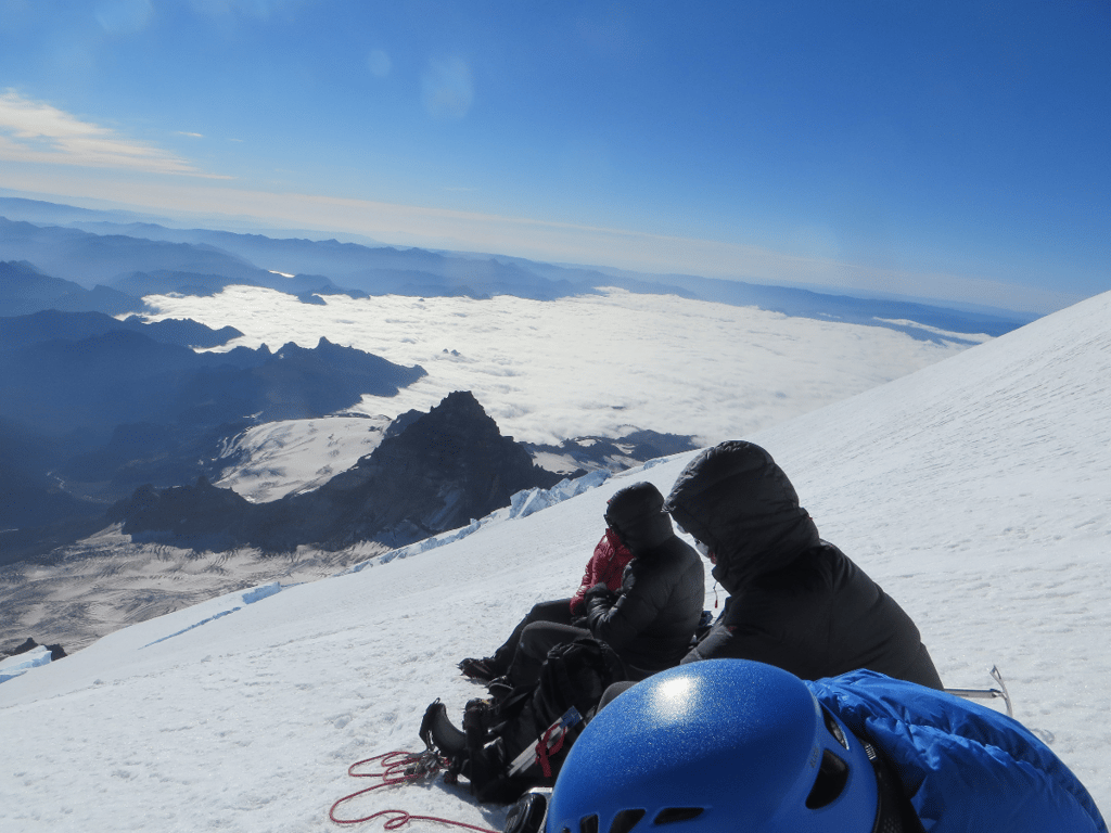 Team taking a rest sitting on steep mountain-side