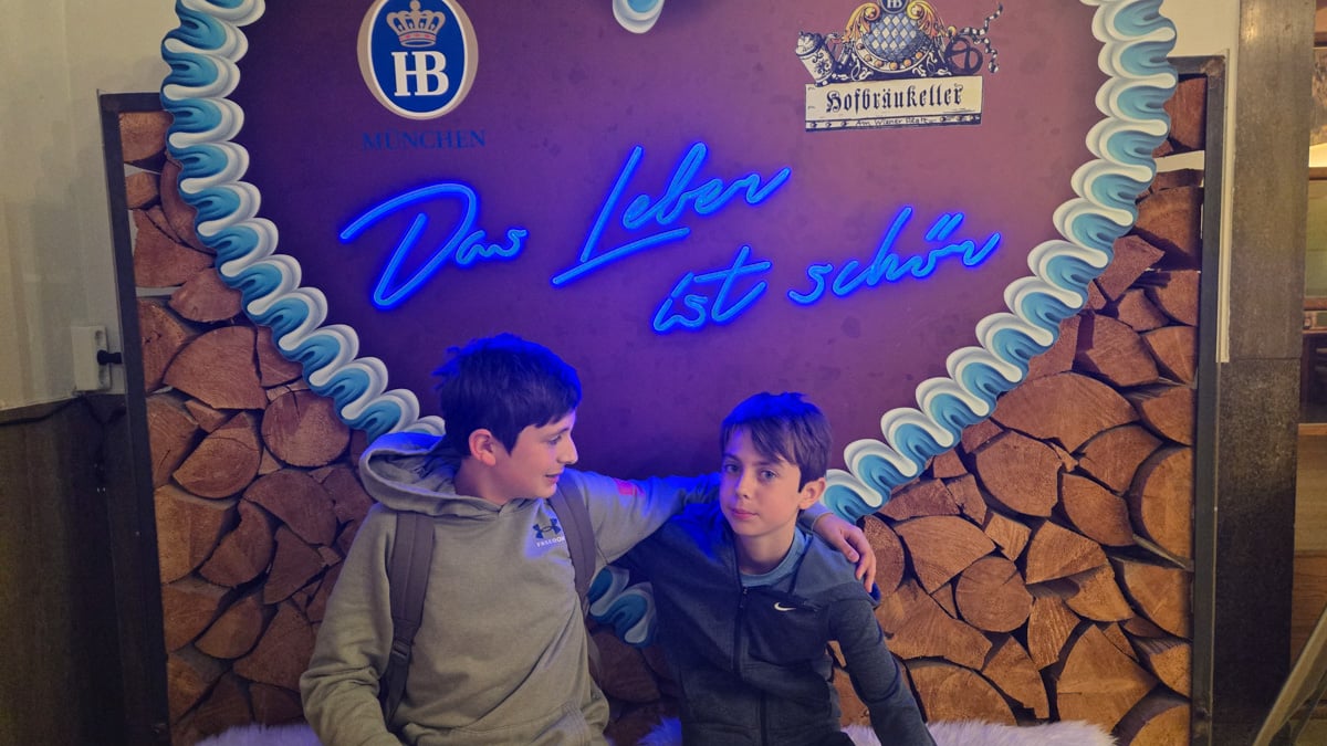 Tyler and Max on a bench with sign reading: Life is Beautiful