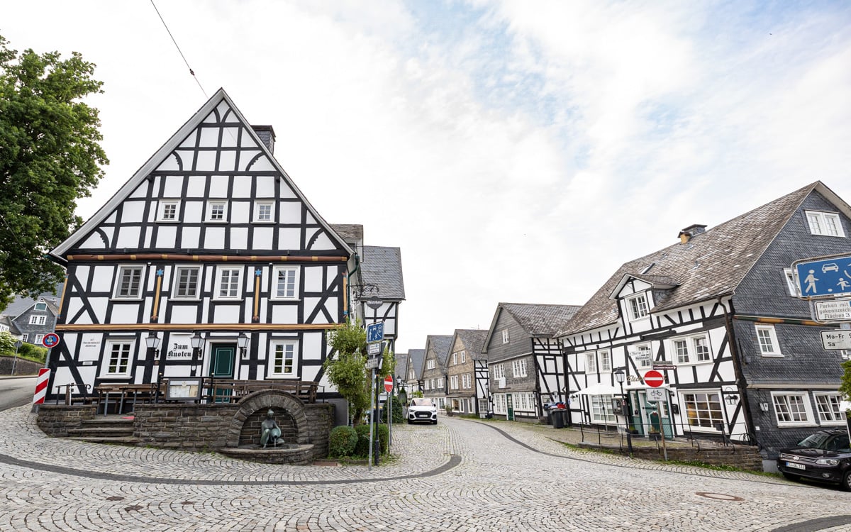 Wide angle view of the hotel, restaurant, and other nearby buildings - all white, half-timbered
